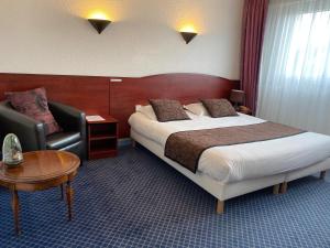 莫尔莱The Originals City, Hôtel Fontaine, Morlaix的配有一张床和一把椅子的酒店客房