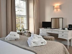 卡恩Lansdowne Strand的一间卧室配有带毛巾的床
