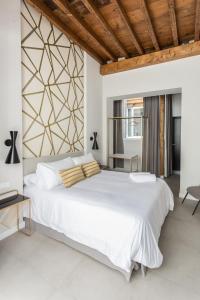 马拉加W Thyssen house的卧室设有一张白色大床和木制天花板。