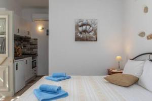 Glinado NaxosVintage House Naxos的一间位于地板上带蓝色毛巾的床的客房