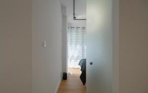 波兹南Villa Wenecja Apartament ALBERO的一间拥有白色墙壁的客房和一扇带窗户的门
