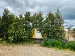 埃基斯蒂尔Við-Bót Riverside Cottage的院子里有白色门的黄色房子