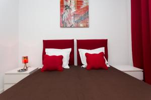 戛纳COTE PORT的卧室配有两张红色和白色的枕头