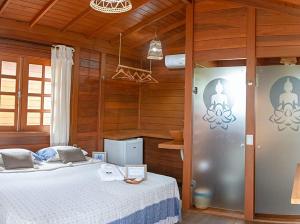 伊塔雷马Pousada Villa del Lótus的卧室配有一张床铺,位于带木墙的房间内