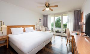 萨加尔德Precise Resort Rügen & SPLASH Erlebniswelt的卧室配有一张白色大床和一张书桌