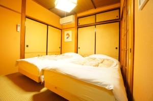 高山Takayama - House - Vacation STAY 85996的黄色墙壁客房的两张床
