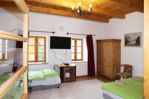 GarábTanya Üdülőház的一间卧室设有两张床,墙上配有电视。