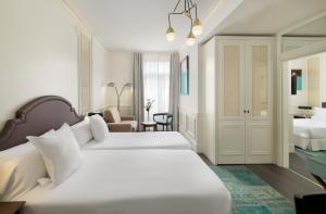 马德里女王别墅H10精品酒店的酒店客房,配有两张床和椅子