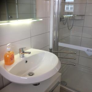 不莱梅Pension RUBIN的白色的浴室设有水槽和淋浴。