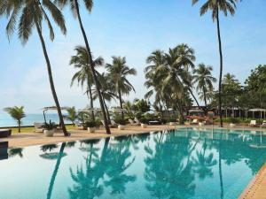 孟买孟买珠瑚海滩诺富特酒店的一座棕榈树和海洋游泳池