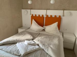 梅拉诺Rennweg 114的一张带白色床单和枕头的床