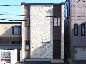札幌Family Tree Guest House的砖砌的建筑,旁边标有标志