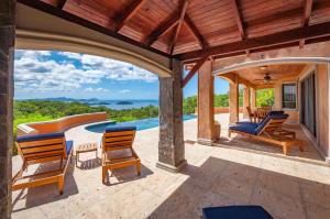 瓜纳卡斯特Ocean-View Villa Above Potrero Overlooking Two Bays的一个带椅子的户外庭院和一个游泳池