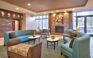盐湖城Holiday Inn & Suites Salt Lake City - Airport West, an IHG Hotel的客厅设有蓝色的沙发和壁炉