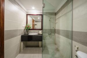 暹粒Smiling Deluxe Hotel的一间带玻璃淋浴和水槽的浴室