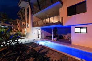 凯恩斯Valle Vista Luxury Apartments的一座晚上设有游泳池的房子