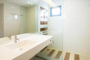 哈德超珊兰哈德巢萨姆蓝渔夫度假村 的白色的浴室设有水槽和镜子