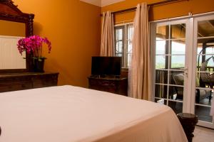 蒙特哥贝Vacation Getaway in Mango Walk Country Club的卧室配有白色的床和窗户。