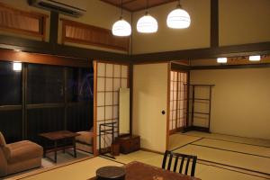 ŌwaniHistorical Ryokan SENYUKAN的客厅配有桌椅和灯