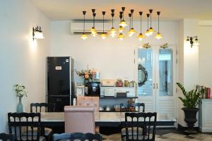 芭堤雅市中心芭堤雅努萨巴酒店的厨房配有桌椅和冰箱。
