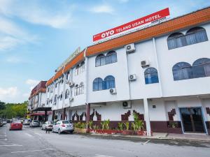米里Super OYO 1018 Telang Usan Hotel Miri的街道边的白色建筑