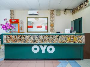 米里Super OYO 1018 Telang Usan Hotel Miri的商店里的一个印花柜台,上面有标志