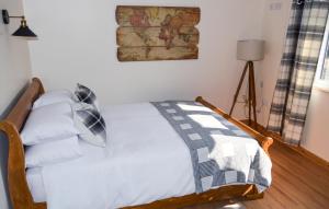 布拉克利Bluebell Cottage at The Old Tractor Barn的一间卧室配有带白色床单和枕头的床。