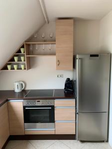 巴拉顿菲赖德Robinson szigete的厨房配有不锈钢冰箱和木制橱柜