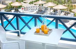 卡马利阳光大饭店 的阳台上的桌子上放两杯橙汁