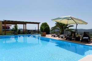 圣布拉什迪阿尔波特尔Hotel Rural Rocha da Gralheira的一个带椅子和遮阳伞的游泳池