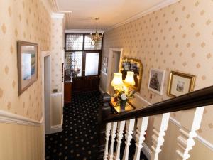 惠特比Crescent Lodge Guest House的走廊上设有楼梯,配有镜子和灯