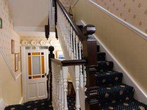 惠特比Crescent Lodge Guest House的房屋内的楼梯,有白色和棕色的楼梯