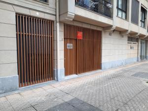 扎鲁亚斯Loft en Zarautz con Parking Hator 2的建筑的一侧有棕色门