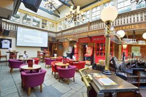 达特福德皇家维多利亚公牛酒店的大楼内的餐厅,配有紫色的桌椅