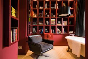 马斯特里赫特Teaching Hotel的一间带椅子和书架的房间