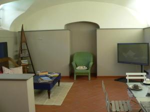 皮斯托亚RESIDENZA LE CICOGNE的客厅配有电视和椅子