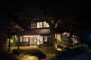 小松市Takigahara Craft & Stay的一座在晚上有树的建筑