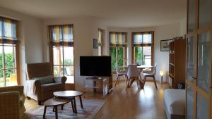Gebertingen帕克普戈博听恩套房的客厅配有电视和桌椅