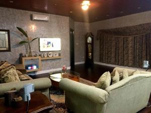 PinamalayanSeacliff Suites Hotel and Resort的客厅配有两张沙发和一台电视机