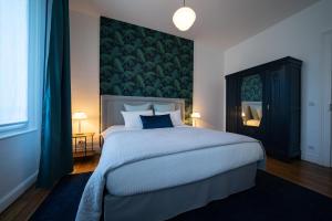兰斯Centre ville - Appartement 3 chambres & Terrasse - La Clé des Sacres的一间卧室设有一张大床和绿色的墙壁