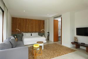 乌布乌布晓月别墅酒店的一间卧室配有一张床、一张沙发和一台电视。