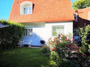 维也纳Christl - Apartment mit Garten und Pool zur Mitbenutzung的一座带橙色屋顶和庭院长凳的房子