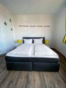 马格德堡apartHOTEL Magdeburg的卧室内的一张床铺,墙上有标志