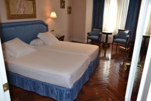 萨拉曼卡阿拉梅达宫酒店的酒店客房,配有一张床和两把椅子
