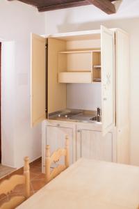 马里内拉Colonna Beach Hotel Marinella的厨房配有白色橱柜和桌子