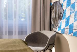 罗森海姆罗森海姆温德姆特里普酒店的靠窗边的椅子,墙上挂着照片