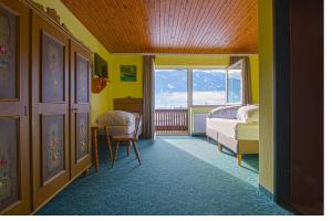 Jenig索勒特酒店的一间卧室配有一张床、一张书桌和一个窗户。