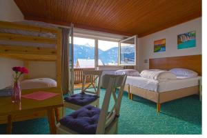 Jenig索勒特酒店的一间卧室配有两张双层床、一张桌子和一张书桌。