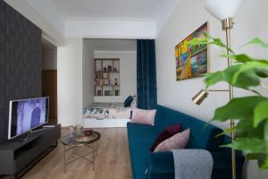 里加Cozy Home Valdemara, free parking, self check-in的客厅配有蓝色的沙发和床。