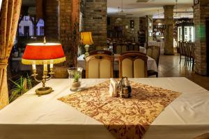 奥得河畔科斯琴巴斯提翁酒店的一张桌子,上面有台灯和桌布